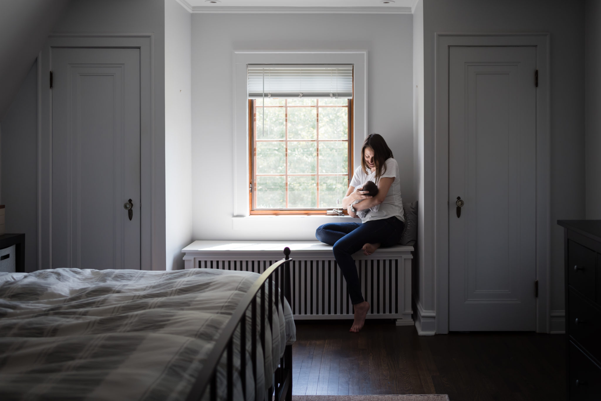 Newborn Lifestyle Photograph mom by window with baby