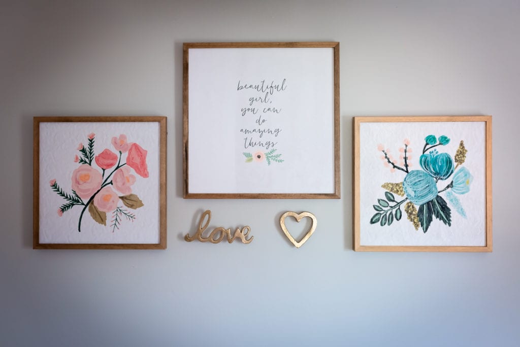 Pictures and the word love in wall art in newborn nursery