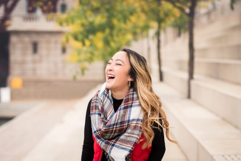 Girl laughing wearing red vest and chunky scarf