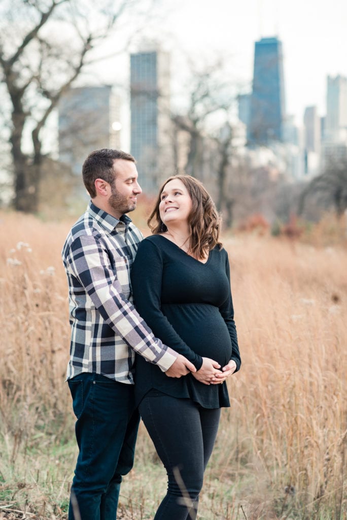 Wife smiling back at husband in Lincoln park nature boardwalk during maternity photography session