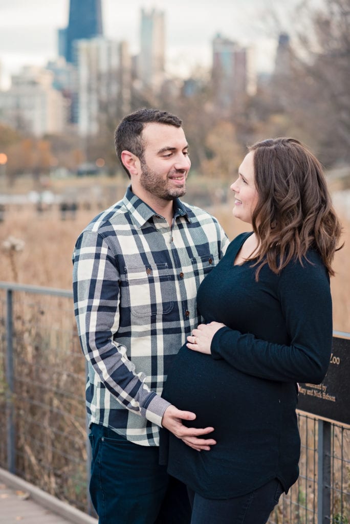 Husband with his hand on his wife's belly during maternity session at Lincoln park nature boardwalk