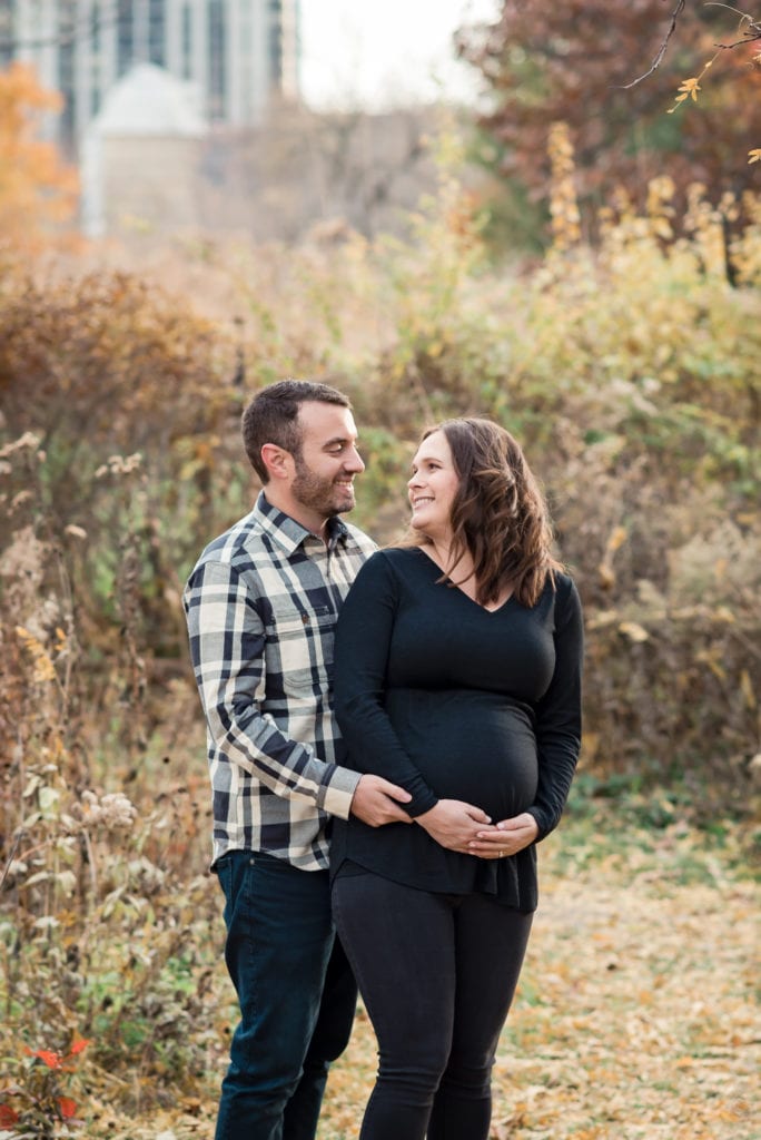 Girl wearing all black and husband in a black and white buffalo plaid shirt maternity pictures Lincoln park nature boardwalk