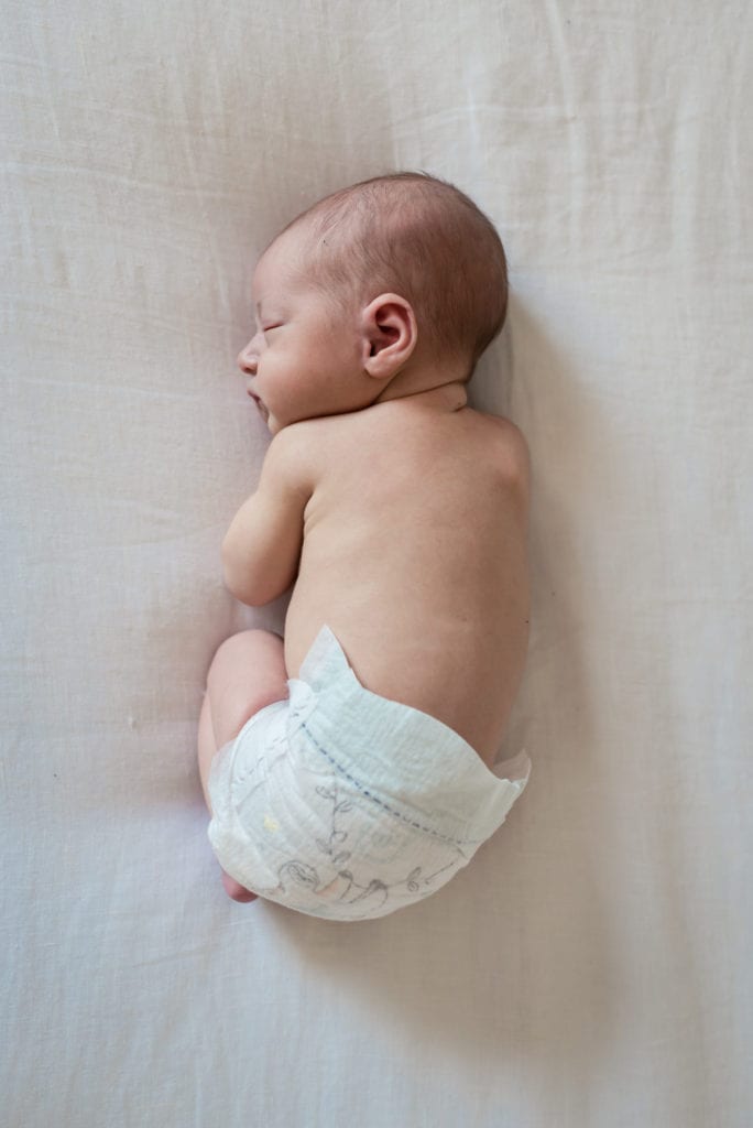 overhead picture of baby on bed in diaper newborn lifestyle photography session los angeles