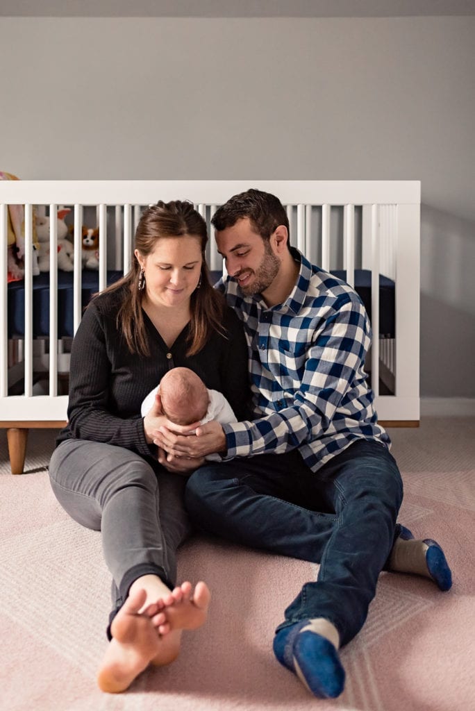 mom and dad sitting on floor in nursery West Hollywood Newborn Pictures