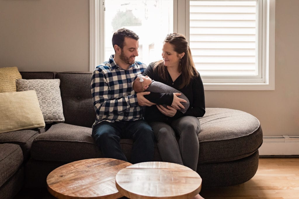 Mom and dad smiling at baby in living room West Hollywood Newborn Pictures