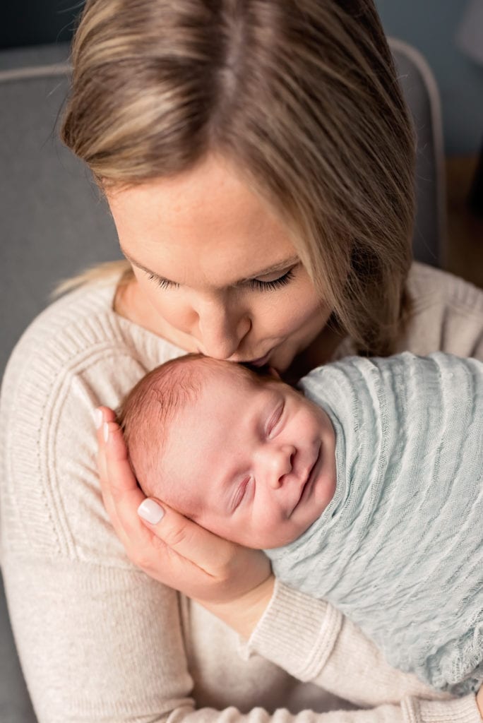 Mom kissing smiling newborn son Culver City Newborn Pictures