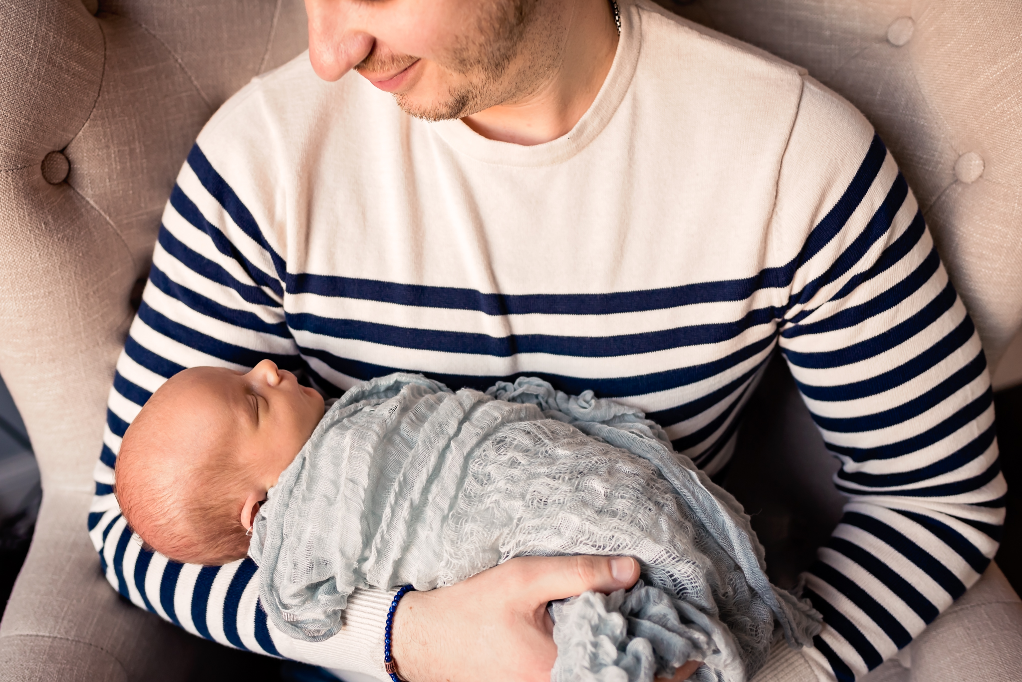dad holding baby in his arms in home session Valley Village Newborn Pictures