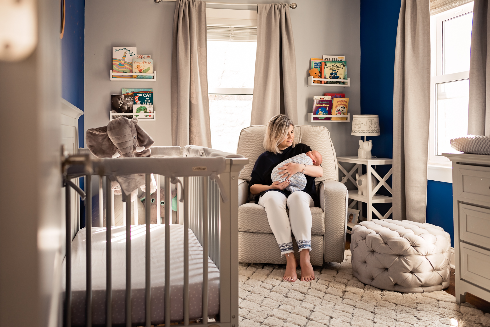 looking in on nursery while mom holds baby in her house Valley Village Newborn Pictures