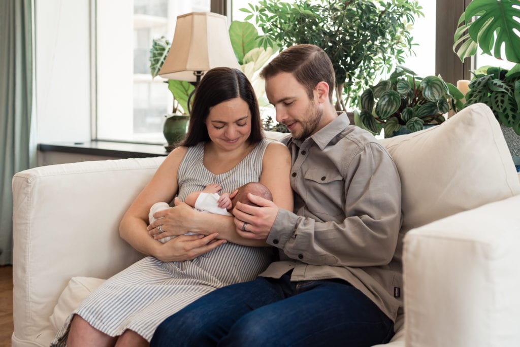 newborn pictures in studio city mom and dad sitting on couch holding baby
