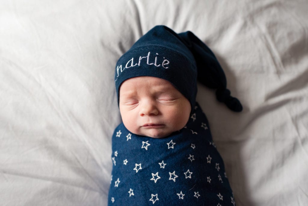 baby with blue wrap with white stars and hat with name embroidered Fresh 48 in hospital session twins